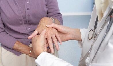 the doctor examines the joints of the hands with arthritis and arthritis